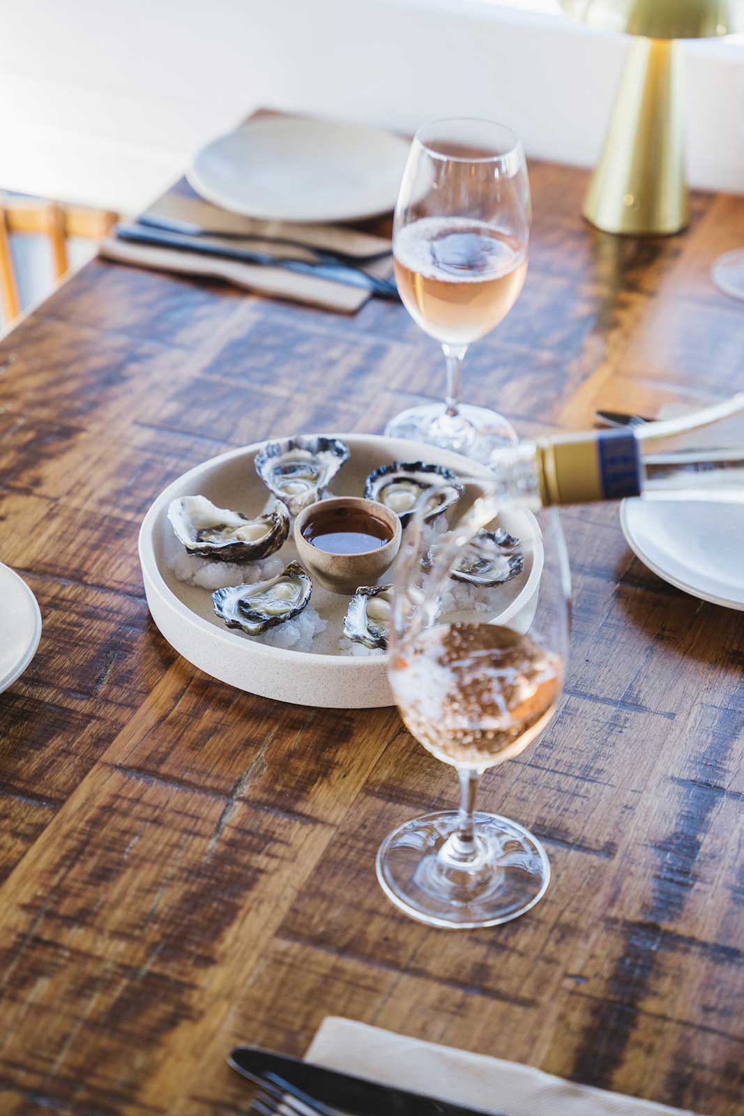 Loft Byron Bay – Oysters and Wine Rosé being poured beside a platter of fresh oysters at Loft Byron Bay